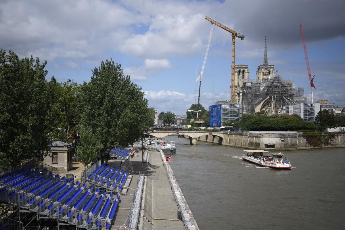 A tourists boat makes its way on the Seine river with stands installed on its banks.