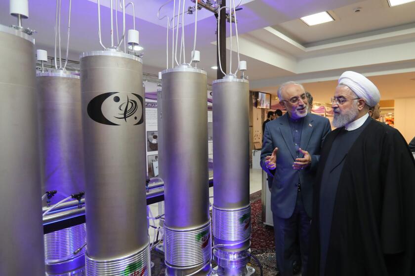 Iranian President Hassan Rouhani (2nd L) listens to the head of Iran's nuclear technology organisation Ali Akbar Salehi (R) during the "nuclear technology day" in Tehran. - Iran's President Hassan Rouhani on September 4, 2019 ordered all limits on nuclear research and development to be lifted, the country's third step in scaling down its commitments to a 2015 deal with world powers.