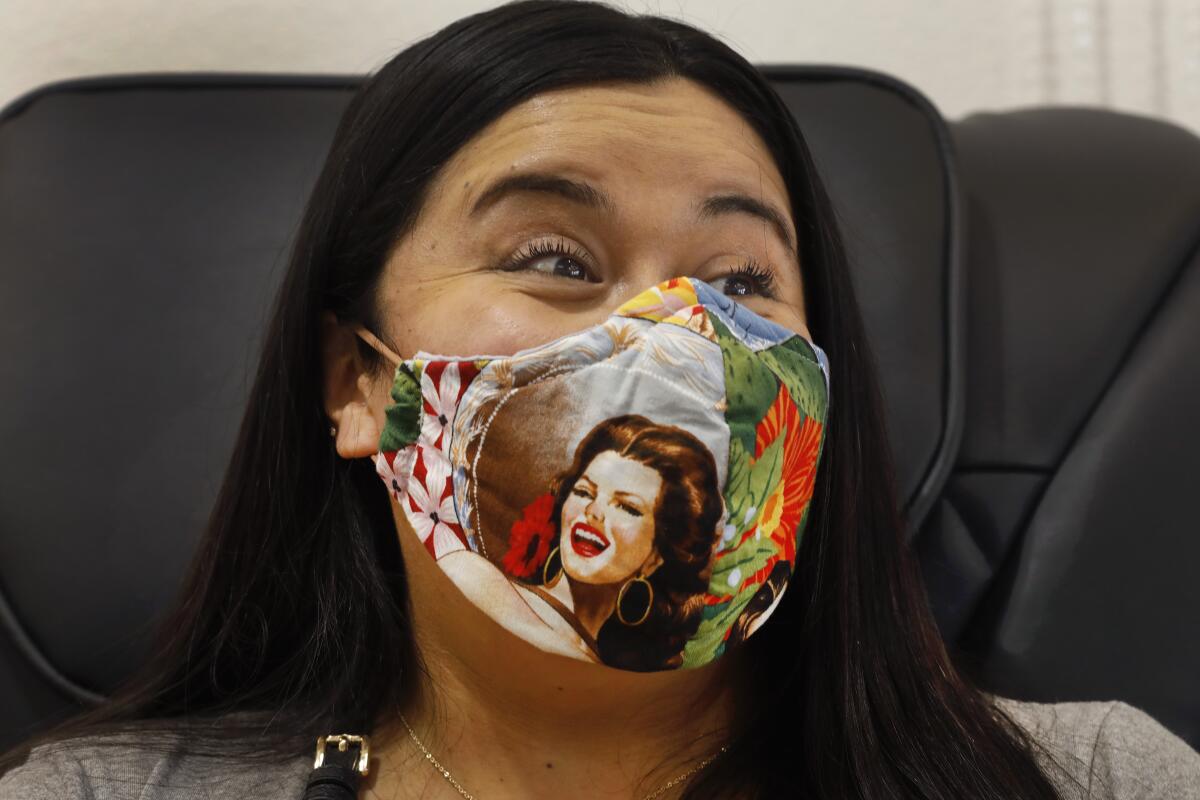 Brittney Robertson wears her face mask while getting her nails done. 