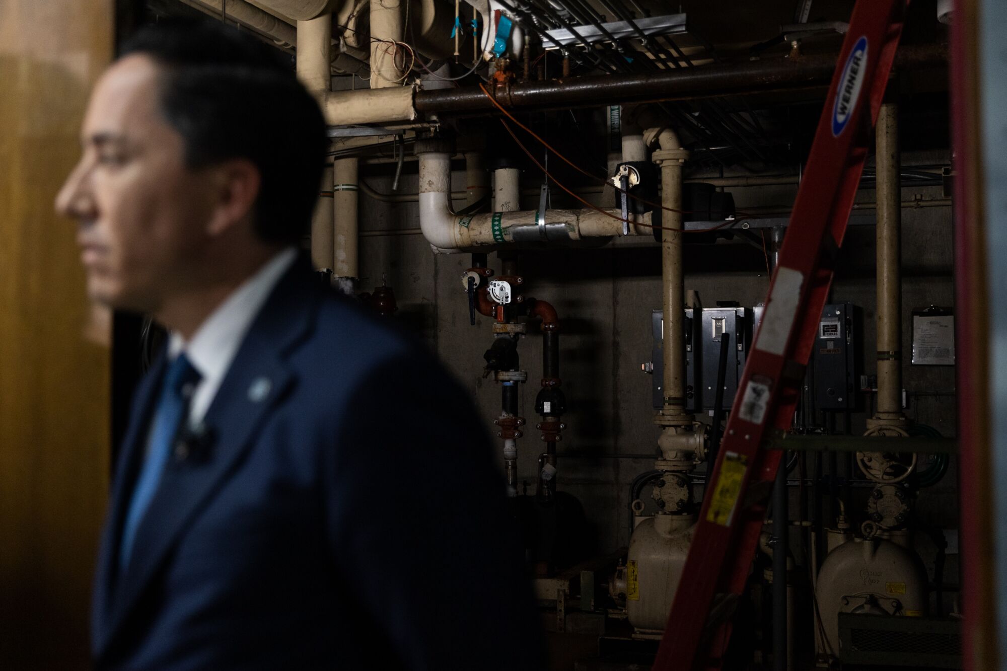 Mayor Todd Gloria stands outside an HVAC room, which contains dated systems, at the City Operations Building.