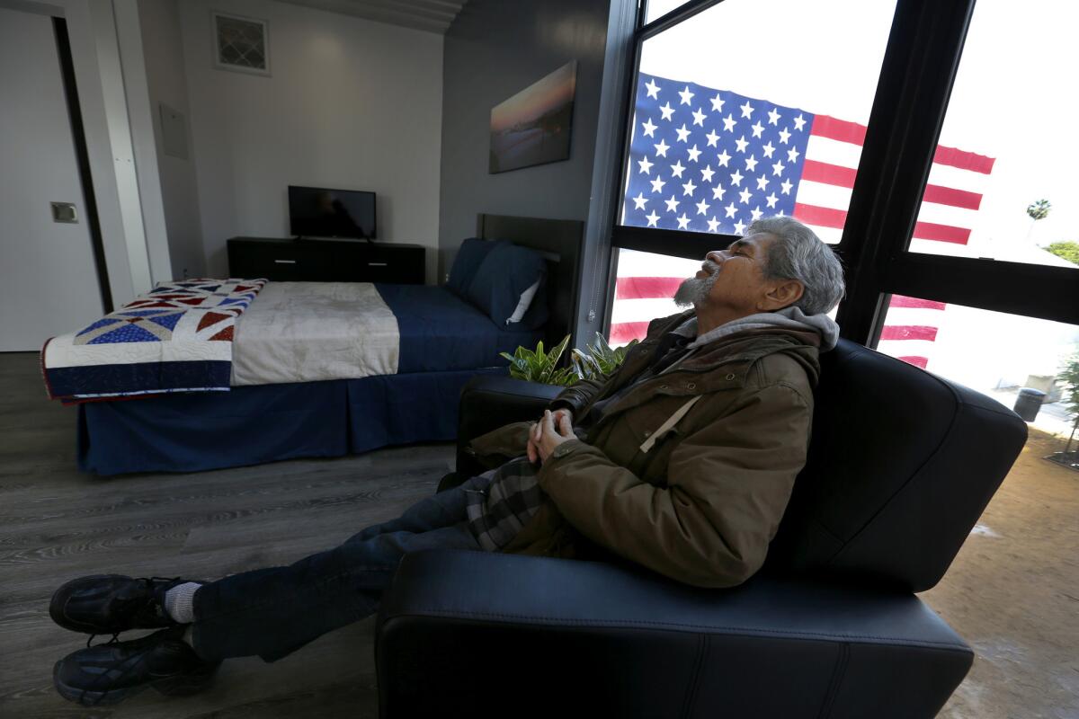 After the grand opening crowds have left, homeless Army veteran Kenneth Salazar, 60, relaxes in a new chair in his new studio apartment. (Allen J. Schaben / Los Angeles Times)
