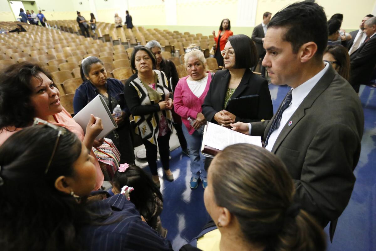 Antonio Plascencia, right, an LAUSD transition team member, listens to parents as they voice concerns following a town hall with L.A. Unified Supt. Michelle King at Nightingale Middle School.