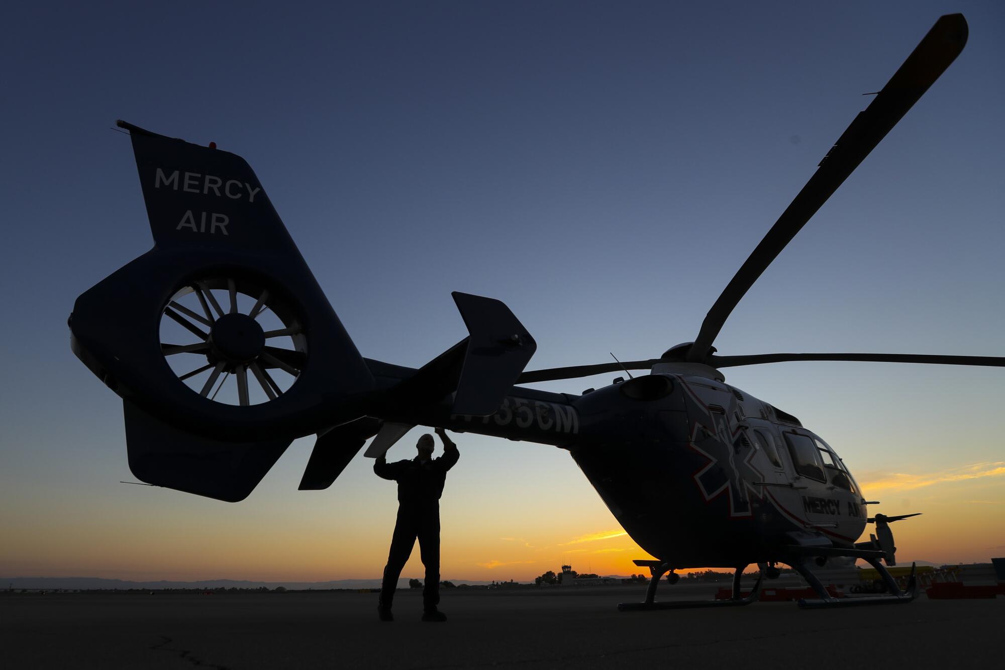 Pilot Michael Bobeck at the start of his 12 hour night shift checks Mercy Air helicopter at Imperial County Airport. 