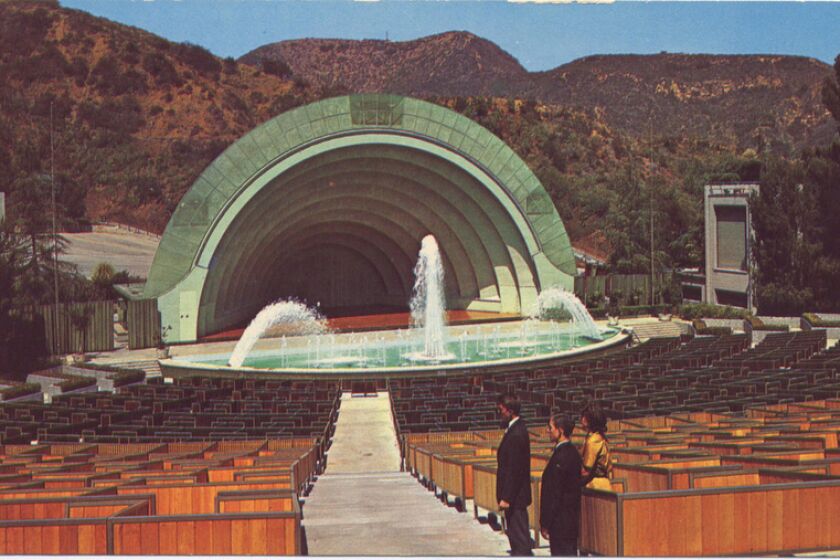 Two men and a woman stand in the aisle of the Hollywood Bowl.