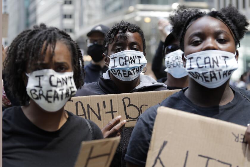People with signs and masks reading "I Can't Breath" are seen during a protest over the death of George Floyd in Chicago, Saturday, May 30, 2020. Protests were held throughout the country over the death of George Floyd, a black man who died after being restrained by Minneapolis police officers on May 25. (AP Photo/Nam Y. Huh)