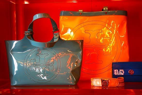 Burchs handbag sales increased 50% last year. From left: gray patent tote, $350; orange and gray contrast T-tote, $325; web belt, $95; and blue resin clutch, $295. More... • Tory Burch is a must-have lifestyle brand Also in Image • Tips for men on wearing short-sleeve, button-up shirts • Che: Man, myth, logo