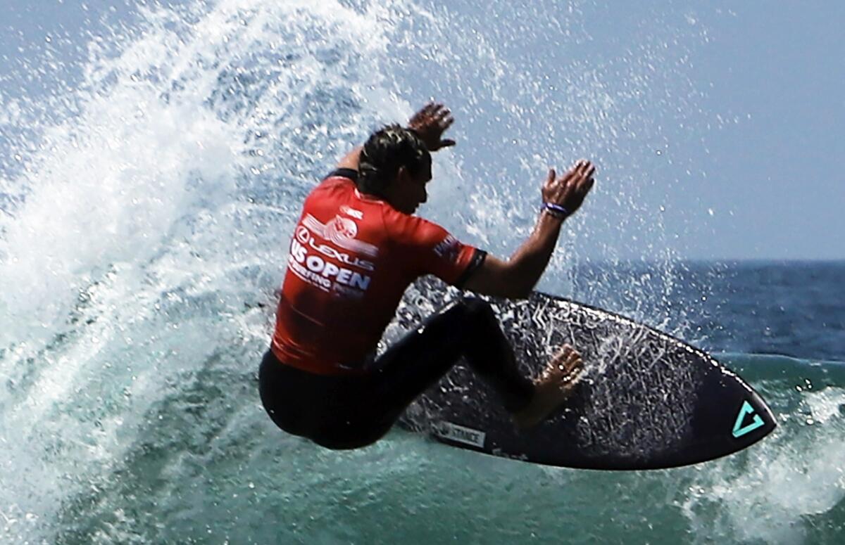 Cole Houshmand of San Clemente rides a wave during the U.S. Open of Surfing at the Huntington Beach Pier on Thursday.