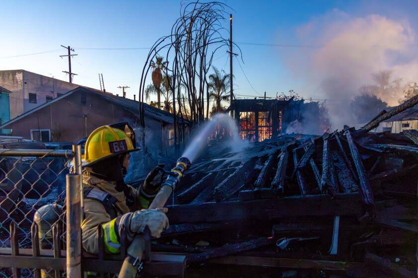 SOUTH LOS ANGELES, CA - NOVEMBER 28: Firefighters fight a massive fire at an apartment building in the framing stages of construction caused evacuations of nearby residents at 1585 E. Vernon St. on Tuesday, Nov. 28, 2023 in South Los Angeles, CA. (Irfan Khan / Los Angeles Times)