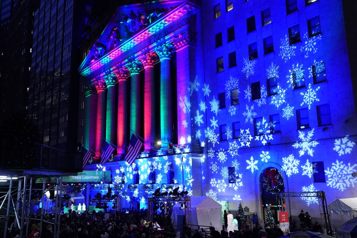 The New York Stock Exchange facade is alight in holiday colors and snowflake patterns.