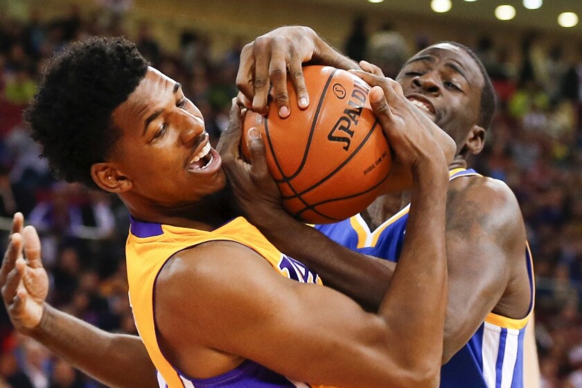 Lakers guard Nick Young battles Golden State's Draymond Green for the ball during a preseason game in Beijing on Tuesday. Young says he had fun visiting China.
