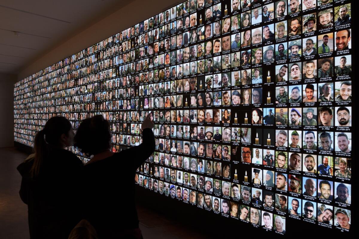 People look at photos on a wall