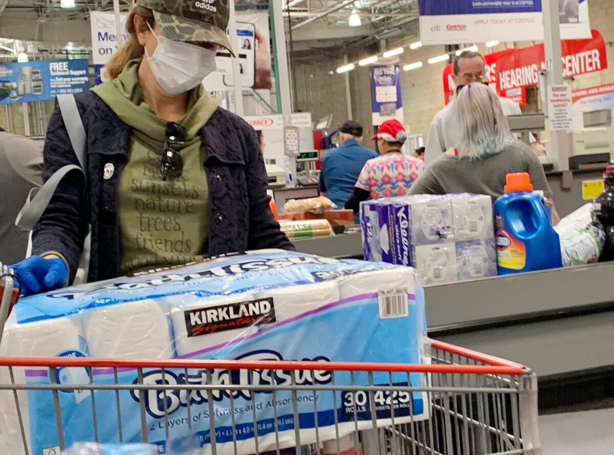 Customers wait in line to buy water and other supplies at Costco