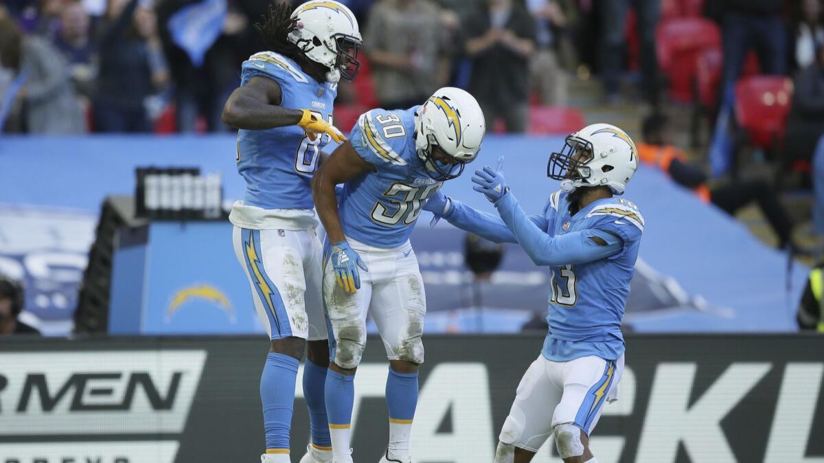 Chargers wide receiver Mike Williams (81) celebrates with running back Austin Ekeler (30), center, after scoring a touchdown during the second half against the Tennessee Titans at Wembley stadium in London on Sunday.