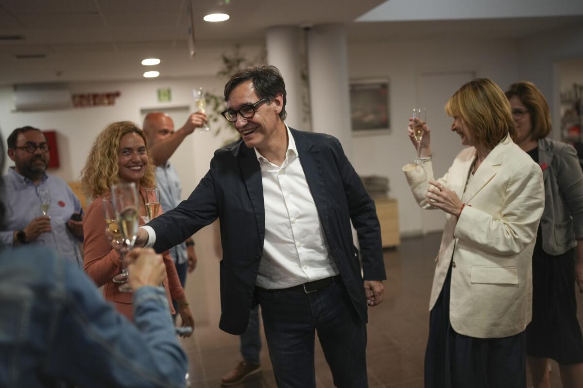 Socialist candidate Salvador Illa makes a toast with members of his team and party colleagues.