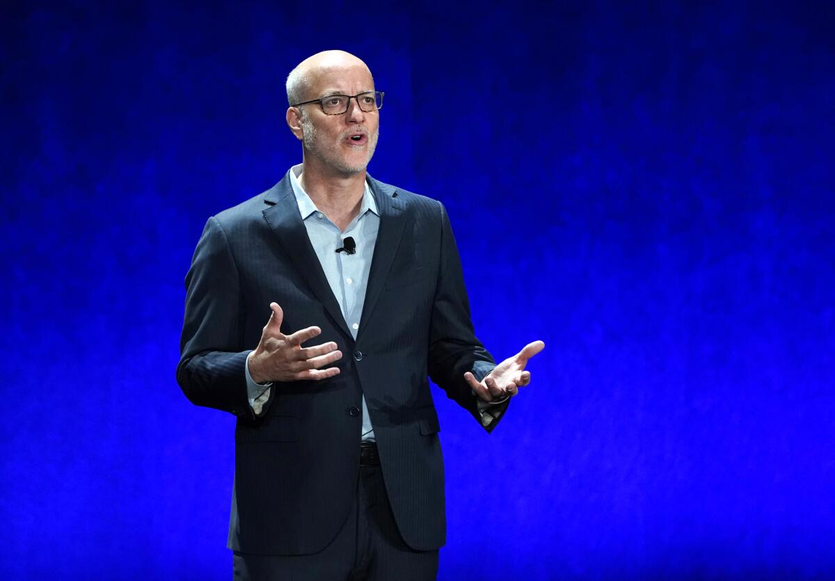 A man in a dark blazer and glasses