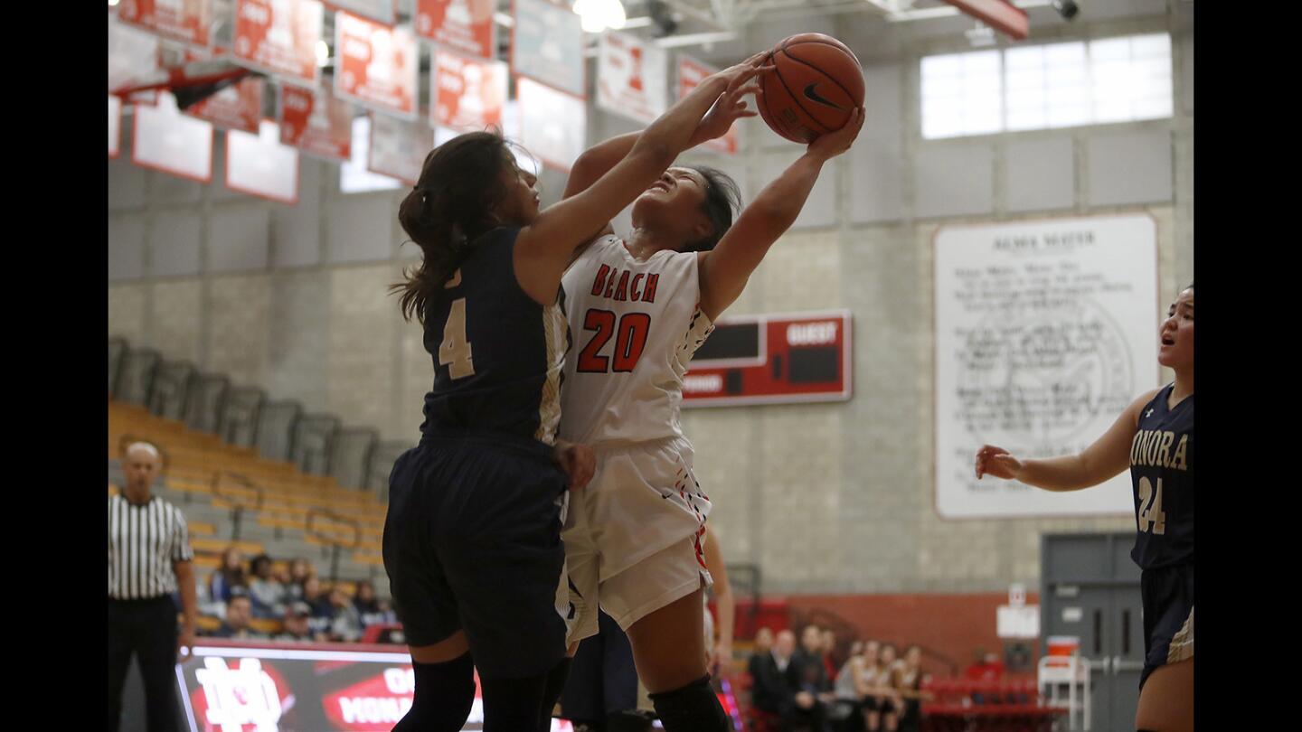 Huntington Beach High's Marisa Tanga (20) is fouled by Sonora's Luz Lizardo (4) during the first half in the Matt Denning Nike Hoops Classic at Mater Dei High on Saturday, January 5, 2019.