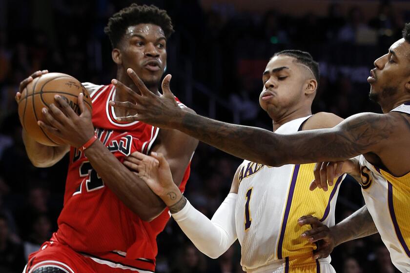 Bulls forward Jimmy Butler looks to pass after his baseline drive was cut off by Lakers guards D'Angelo Russell (1) and Nick Young during the first half.