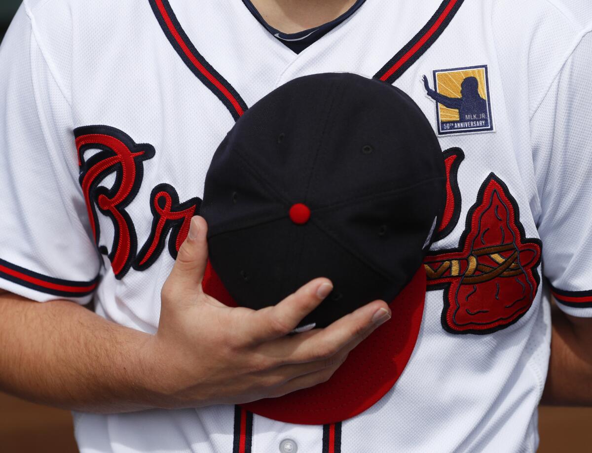 A member of the Atlanta Braves staff wears a patch marking the 50th anniversary of the death of civil rights leader Rev. Martin Luther King Jr. before a baseball game against the Washington Nationals in Atlanta.