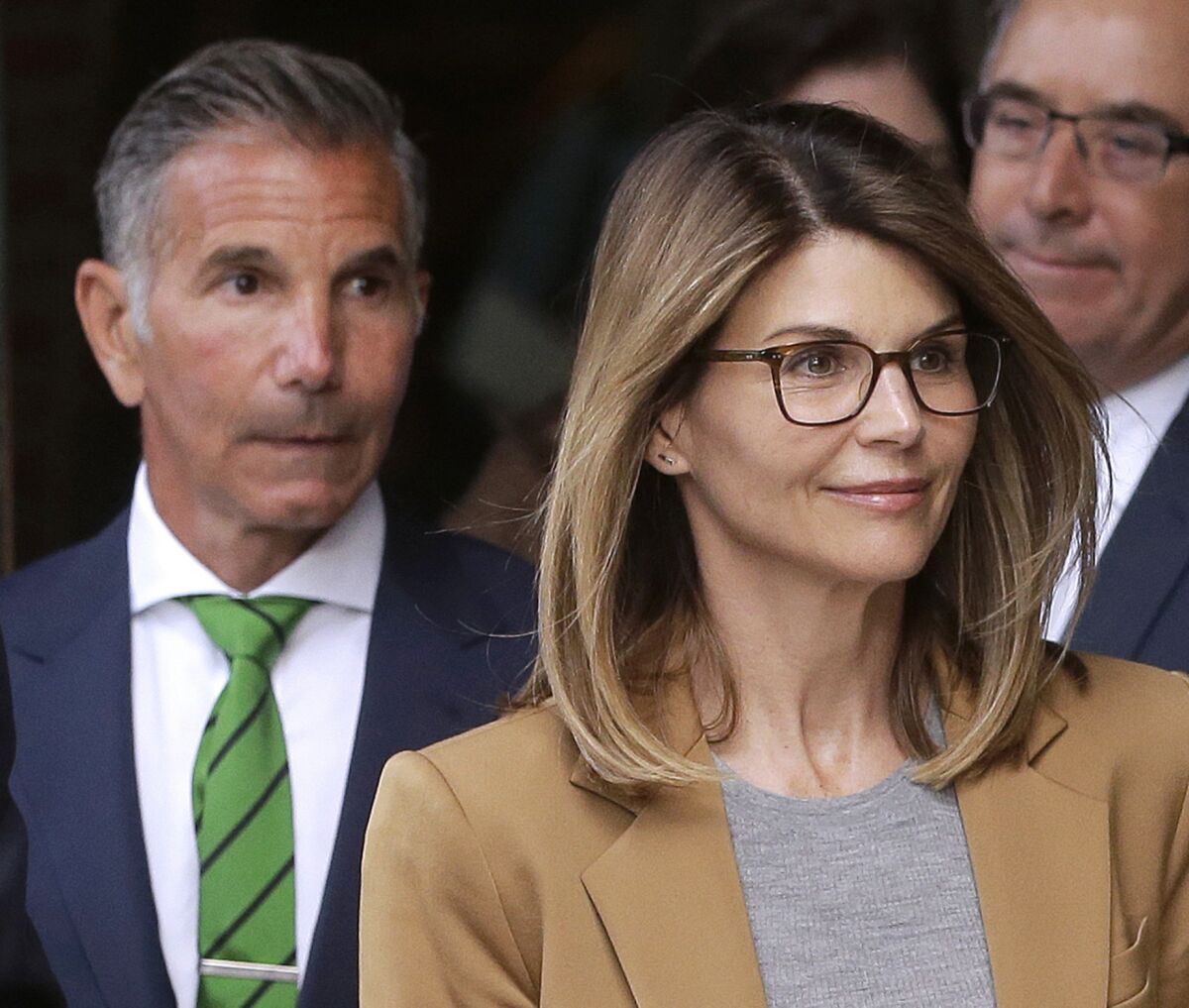 Lori Loughlin, front, and husband Mossimo Giannulli, left, leave court.