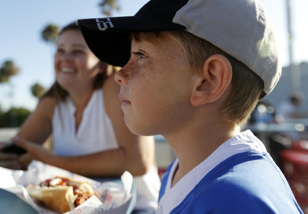 Mychal and Liam Schottler, of Long Beach, munch on Dodger Dogs