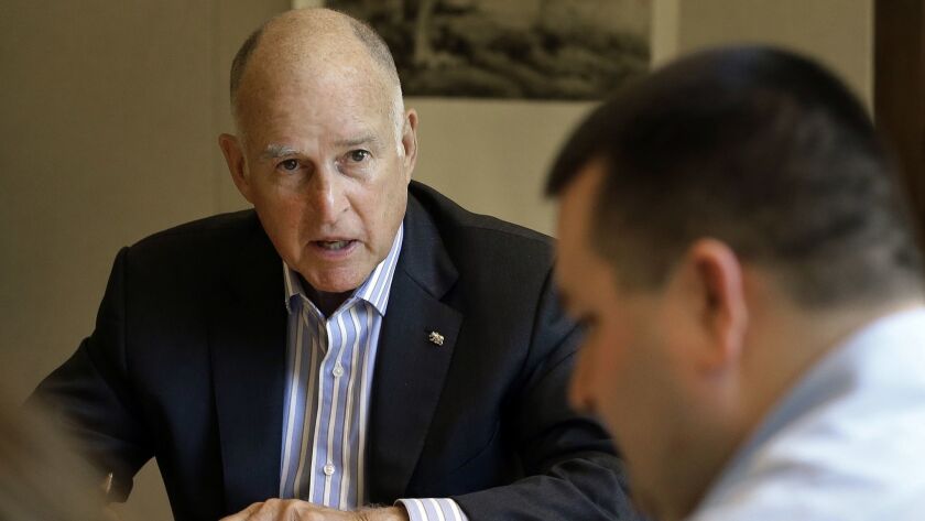 Gov. Jerry Brown discusses a bill with staff in his state Capitol office in 2017. Brown has enjoyed the same kind of privilege as his predecessors: The Legislature almost never attempts to override a California governor's veto.