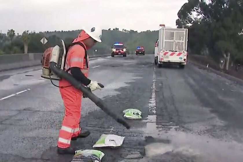 Work crews work on pothole repairs on the 71 Freeway Wednesday morning after 15 vehicles with flat tires were reported on the right shoulder of the freeway near Valley Boulevard Tuesday night.