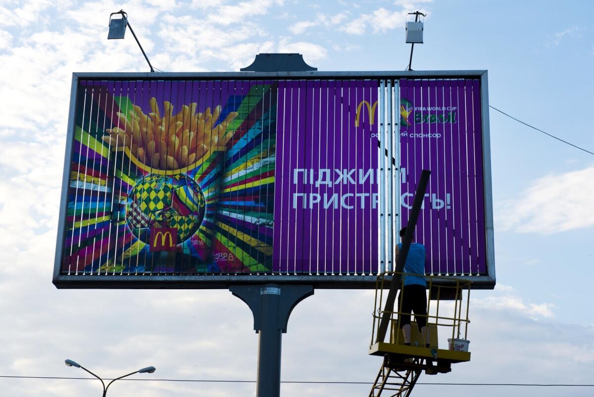 A worker takes down a McDonald's ad in Donetsk, an eastern Ukraine city where the three U.S. fast-food franchises have been forced to close amid fighting spurred by pro-Russia separatist land grabs.