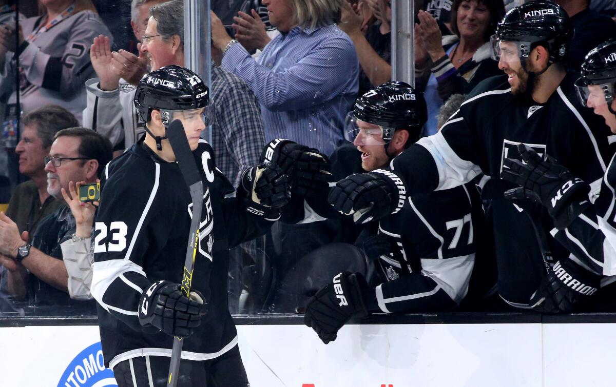 Kings right wing Dustin Brown is congratulated by teammates after scoring against the Oilers in the first period Thursday night at Staples Center.