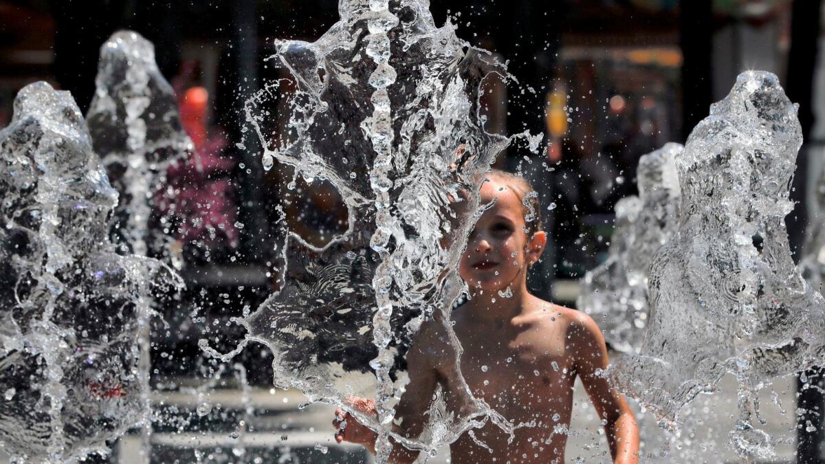 A child plays in a fountain in Bucharest, Romania, on Thursday. Forecasters warned the temperature could hit 107.