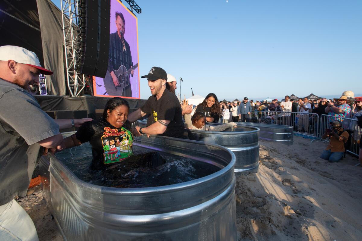 Sisters Kiara Taylor, 21, and Milani Rice, 17, of Compton get baptized at Huntington State Beach.