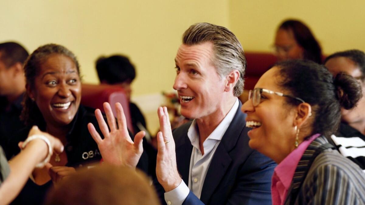 Gavin Newsom shares a laugh over coffee and breakfast with State Sen. Holly Mitchell, left, and Assemblywoman Sydney Kamlager-Dove, at a campaign tour stop at CJ's Cafe in Los Angeles on Monday, Nov. 5, 2018.