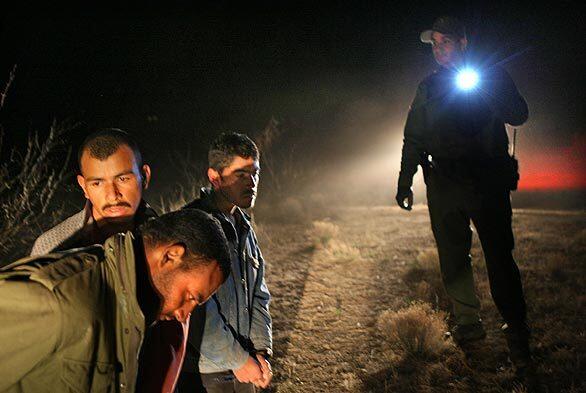 U.S. Border Patrol Agent Jose Portillo keeps an eye on suspected Mexican drug smugglers who were tracked and arrested in the desert near Rodeo, N.M.