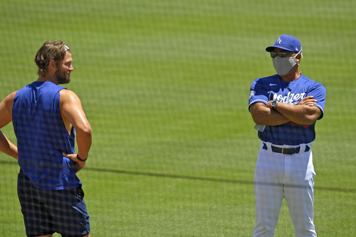 Dodgers pitcher Clayton Kershaw, left, talks with manager Dave Roberts during a practice session.
