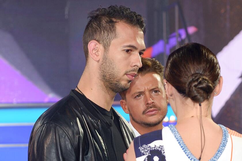 At left, Andrew Tate and Ryan Ruckledge chats to presenter Emma Willis at the Big Brother house at Elstree Studios 