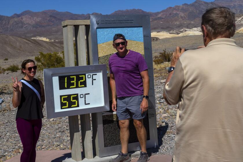 Melissa Bolding and Bryan Bolding from Oklahoma City pose for a photo next to a thermometer displaying a temperature of 132 degrees Fahrenheit / 55 degrees Celsius at the Furnace Creek Visitors Center, in Death Valley National Park, Calif., Sunday, July 7, 2024. Forecasters said a heat wave could break previous records across the U.S., including at Death Valley. (AP Photo/Ty ONeil)
