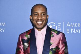 A man smiling in a floral suit against a blue background