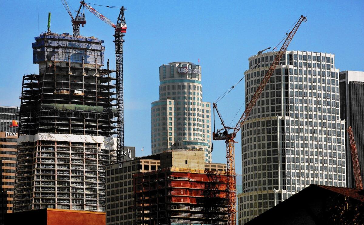 When the Wilshire Grand Center, left, is completed next year, it will eclipse the U.S. Bank Tower, center, as the tallest building in Los Angeles. It will also be the tallest in the West -- for a while.