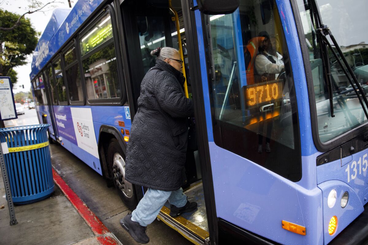 Dora Mayen, who works as a housekeeper, boards a bus after meeting for a morning coffee together with other housekeepers at a cafe near UCLA.