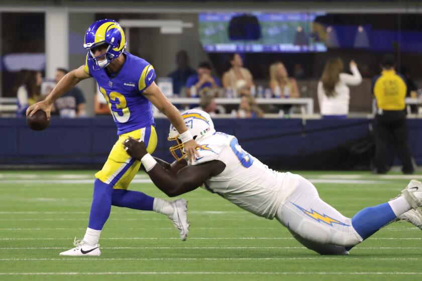 INGLEWOOD, CA - AUGUST 12: Rams quarterback Stetson Bennett gets sacked by Chargers defensive lineman CJ Okoye for a 16-yard loss in the fourth quarter during the Rams and Chargers preseason game at SoFi Stadium in Inglewood, CA on Saturday, Aug. 12, 2023. (Myung J. Chun / Los Angeles Times)