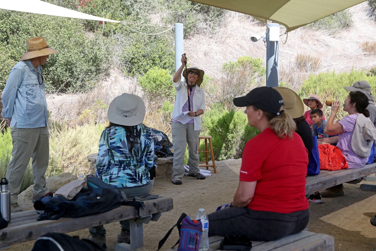 Crystal Cove State Park volunteer Dana Hunter, center, goes over the benefits of using hiking poles.