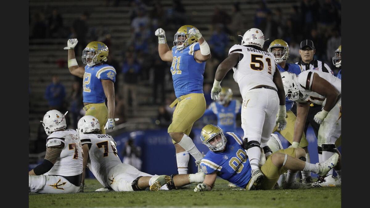 UCLA defensive lineman Jacob Tuioti-Mariner celebrates after tackling Arizona State quarterback Manny Wilkins and bringing to a halt a drive in the fourth quarter.