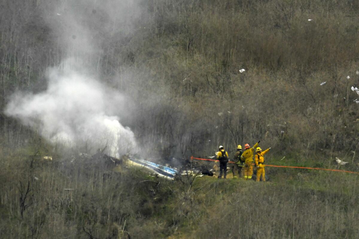 FILE - Firefighters work the scene of a helicopter crash where former NBA basketball star Kobe Bryant died in Calabasas, Calif., Jan. 26, 2020. Bryant's widow is taking her lawsuit against the Los Angeles County Sheriff's Department and Fire Department to a federal jury seeking compensation for photos deputies shared of the remains of the NBA star, his daughter and seven others killed in a helicopter crash in 2020. (AP Photo/Mark J. Terrill, File)