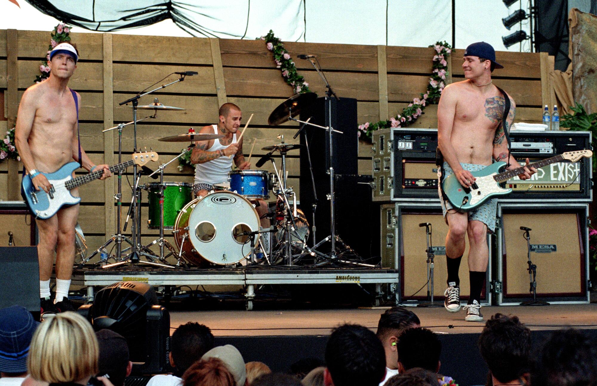 Three men in their underwear play music on stage