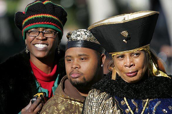 Ngozi Klee, left, Isiah Zemault and Auset Zemault enjoy the 32nd annual Kwanzaa festival in Leimert Park. Kwanzaa, which began Friday, is a weeklong holiday celebrating African heritage.