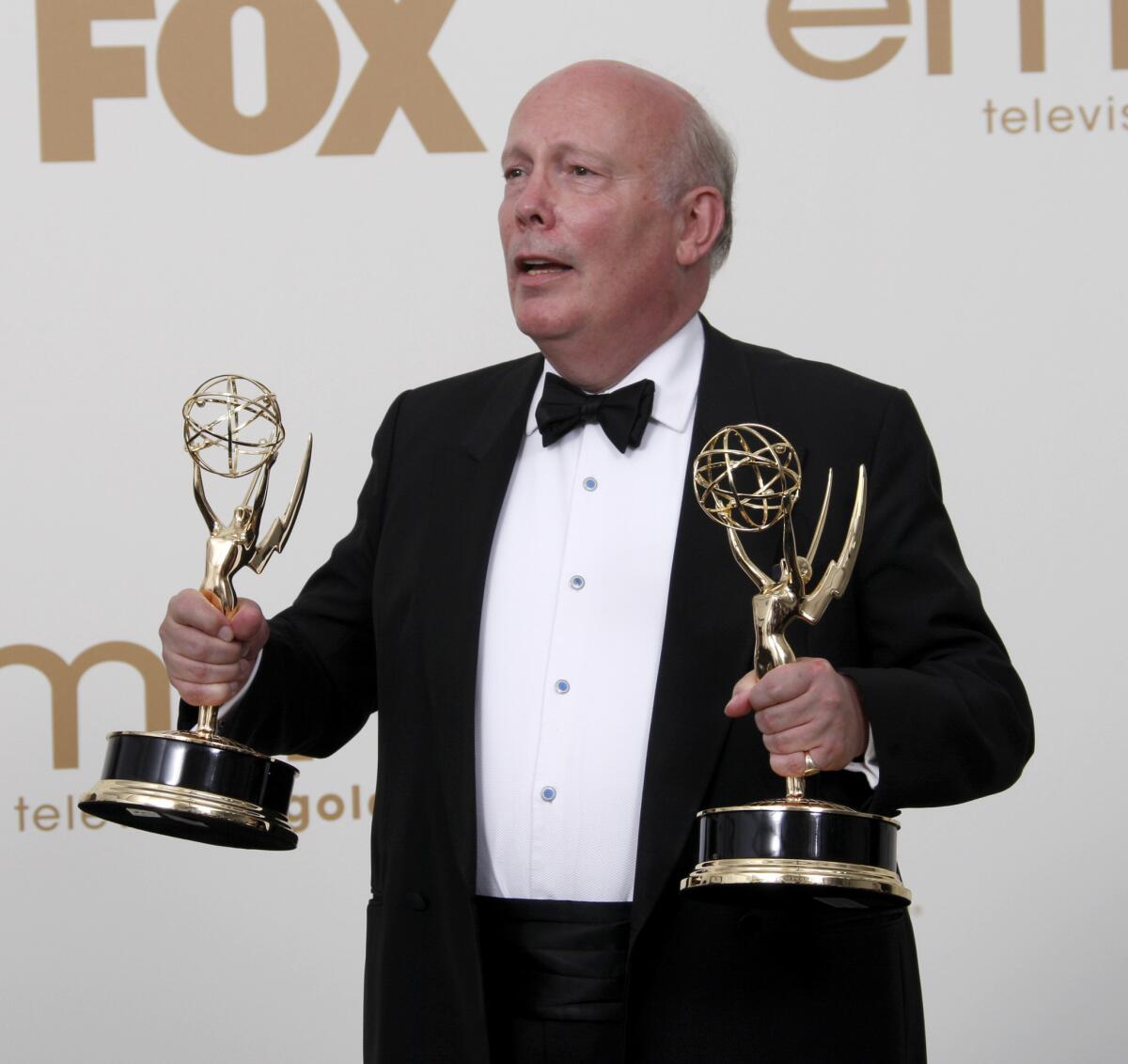 "Downton Abbey" creator Julian Fellowes holds Emmys awarded to his series in 2011.