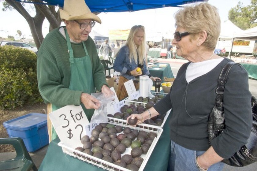 Wall sells Hass avocados at the Malibu farmers market. In the background is Bibi Jordan, another non-certified grower, who offers local Meyer lemons.