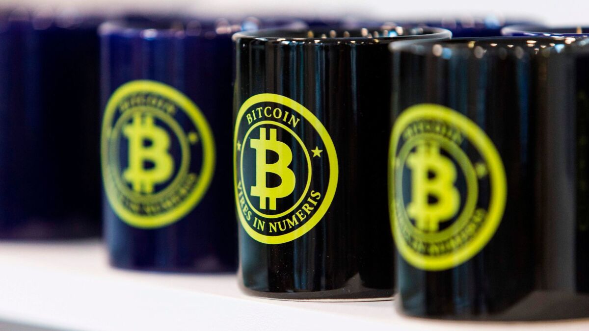 Mugs with the bitcoin logo are displayed for sale at La Maison du Bitcoin in Paris.