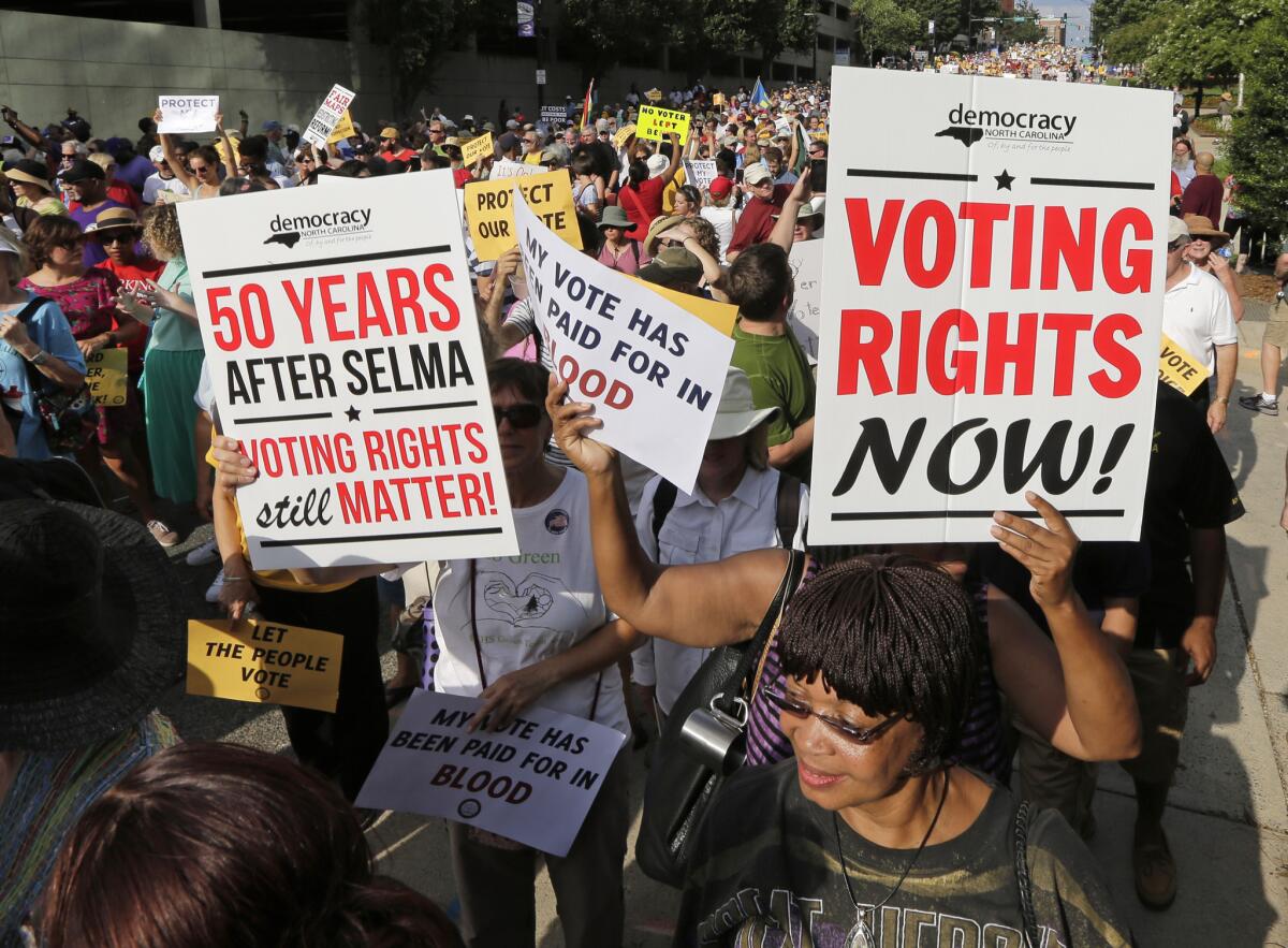 Demonstrators march through the streets of Winston-Salem, N.C. on July 13, 2015, after the beginning of a federal voting rights trial challenging a 2013 state law.