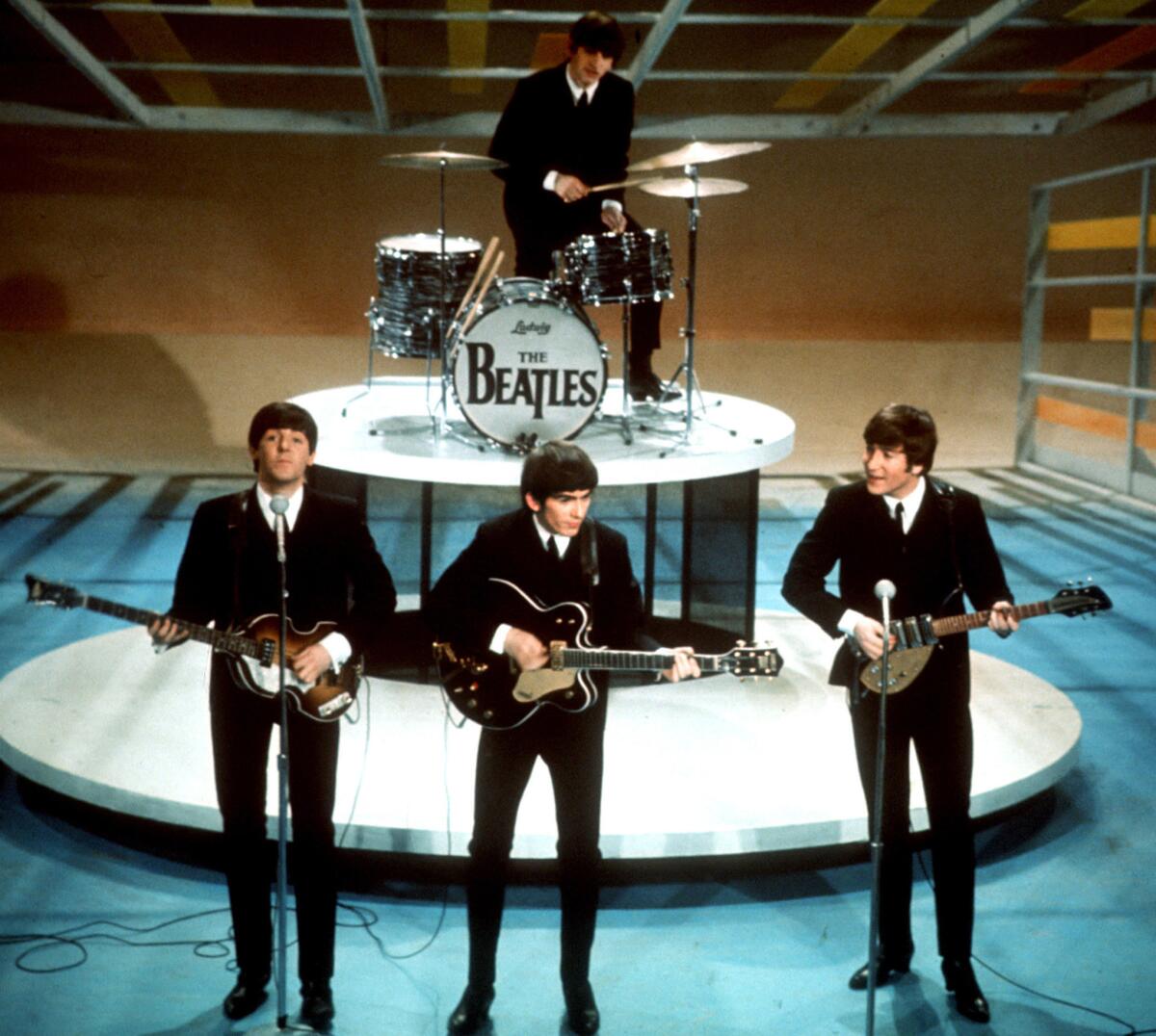 The four members of the Beatles perform on a TV soundstage in the 1964