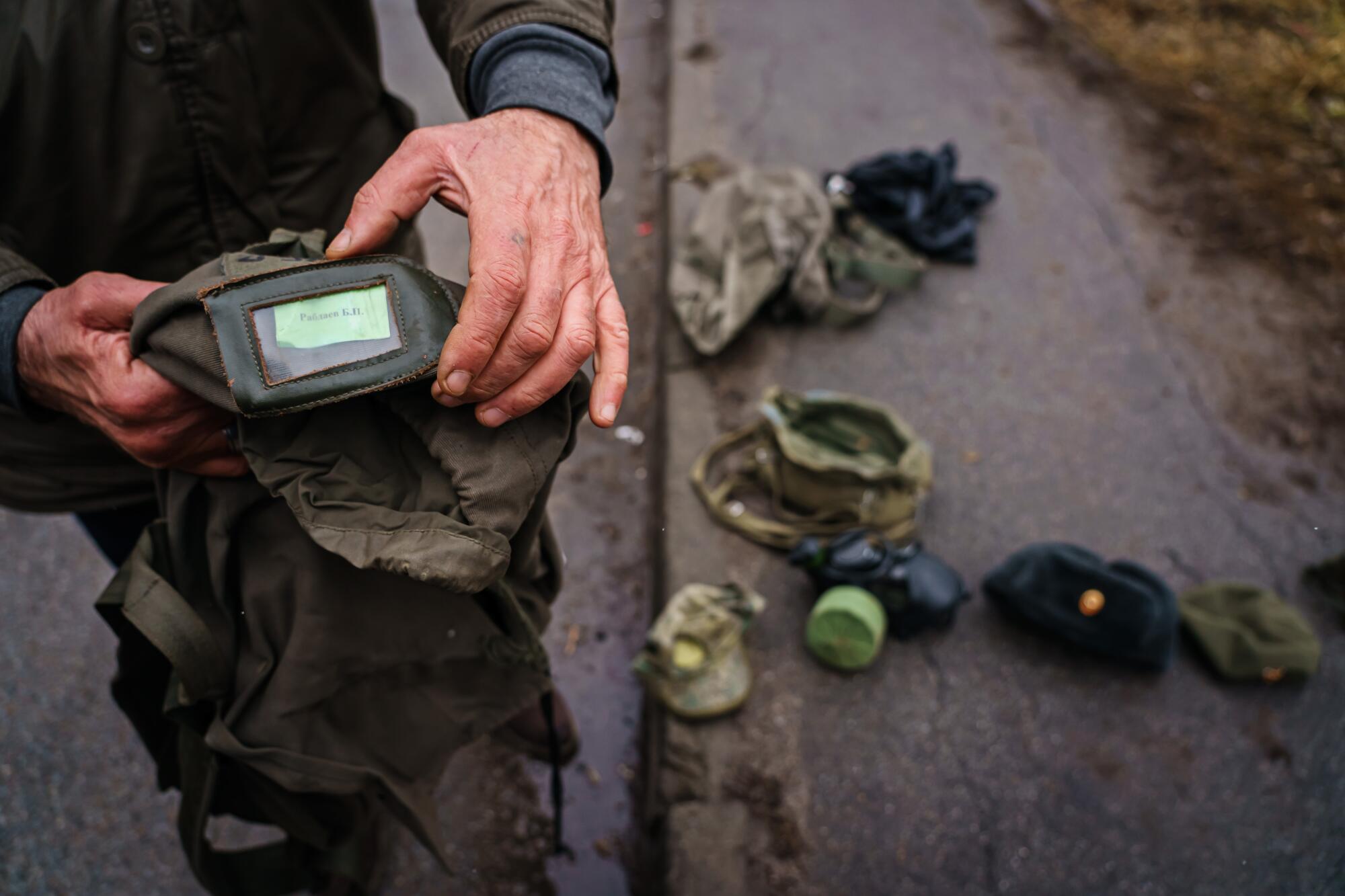 A Ukrainian soldier displays military items collected from Russian forces in Sytnyaky, Ukraine.